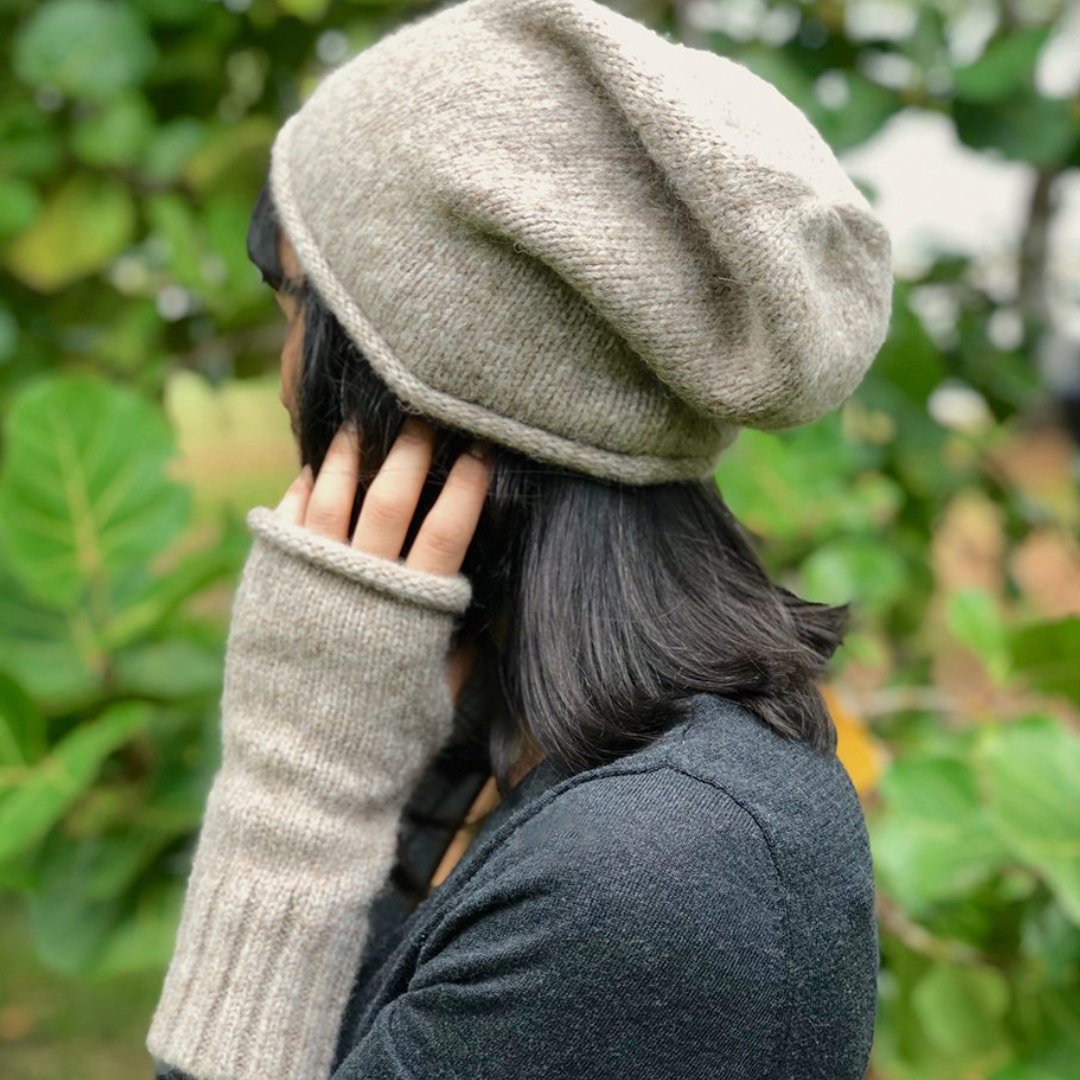 Woman with dark hair wearing beige knit Alpaca beanie